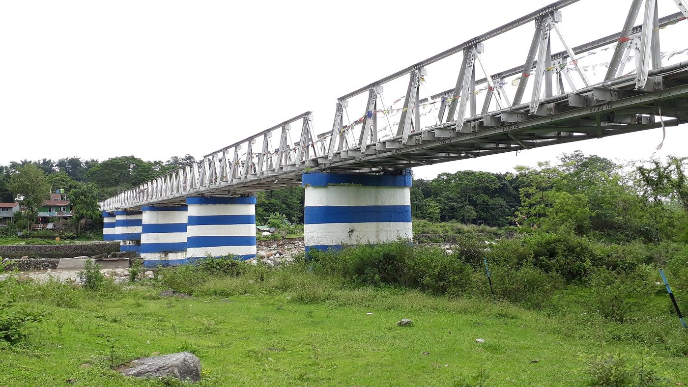 The old steel Dudhia bridge over the Balason river on blue and white pillars